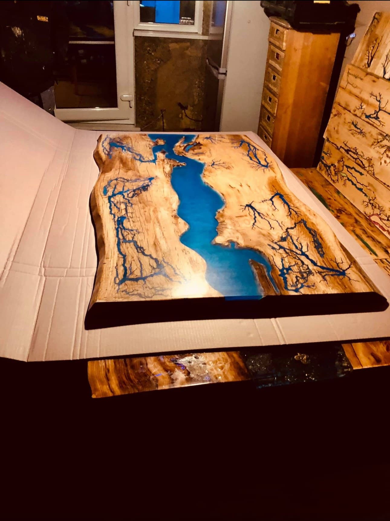 Finished Blue River tabletop on packaging ready for delivery, Lichtenberg branching either side of the resin channel