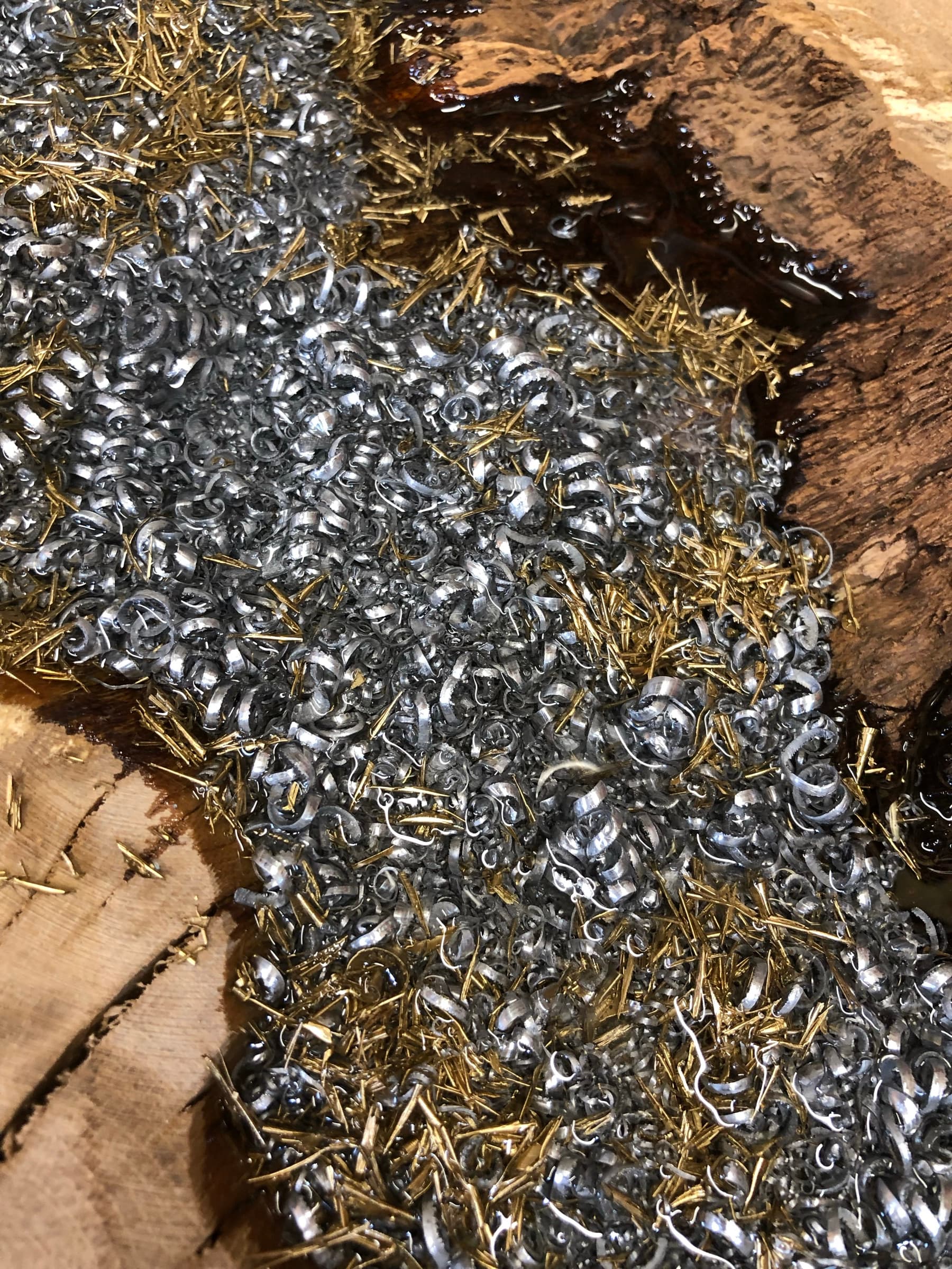 Close view of raw steel shavings and brass pins arranged before casting