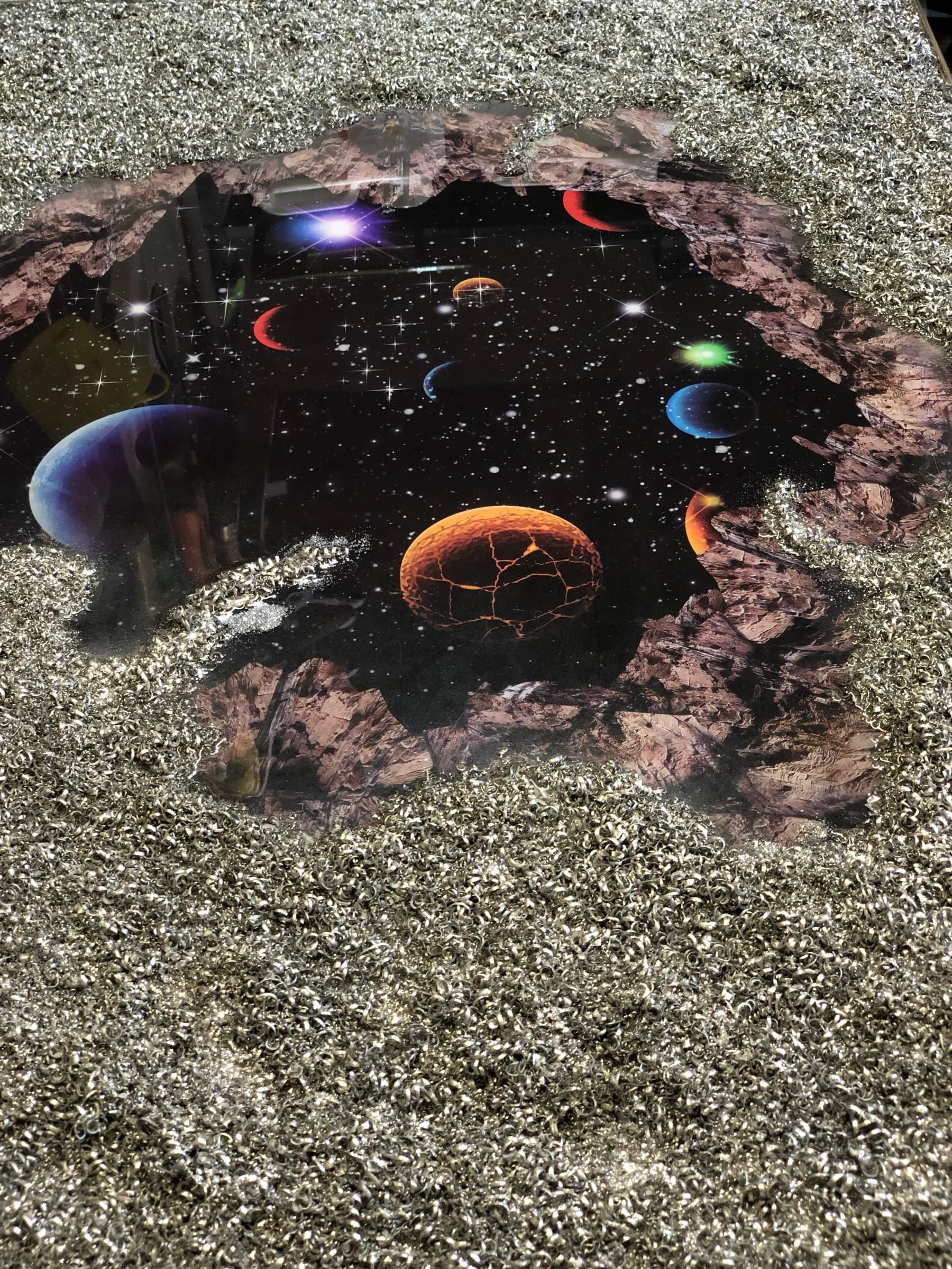 Close view into the painted starfield and planets through the broken opening