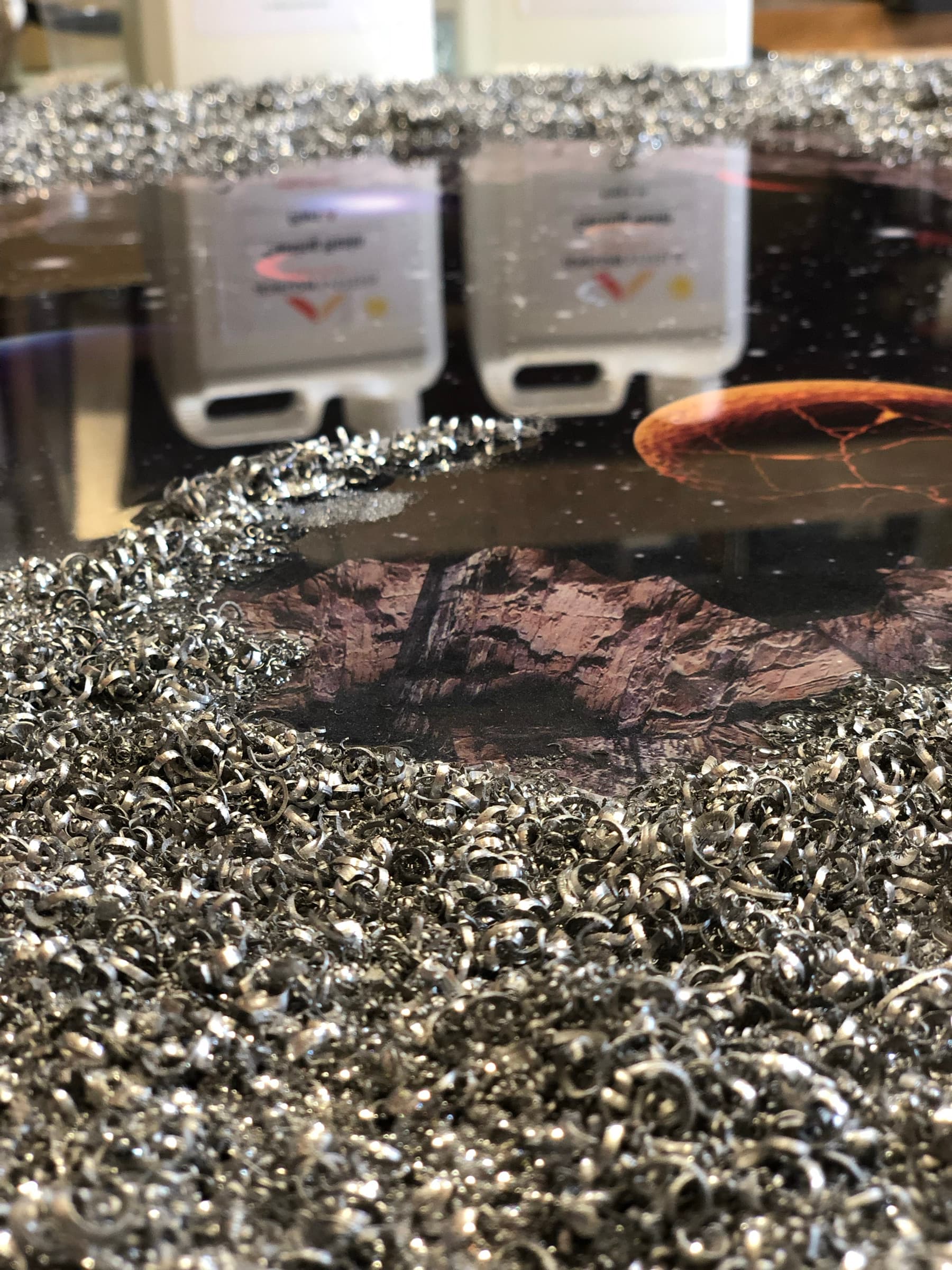 Steel wool shavings and casting resin materials laid out beside the piece, workshop
