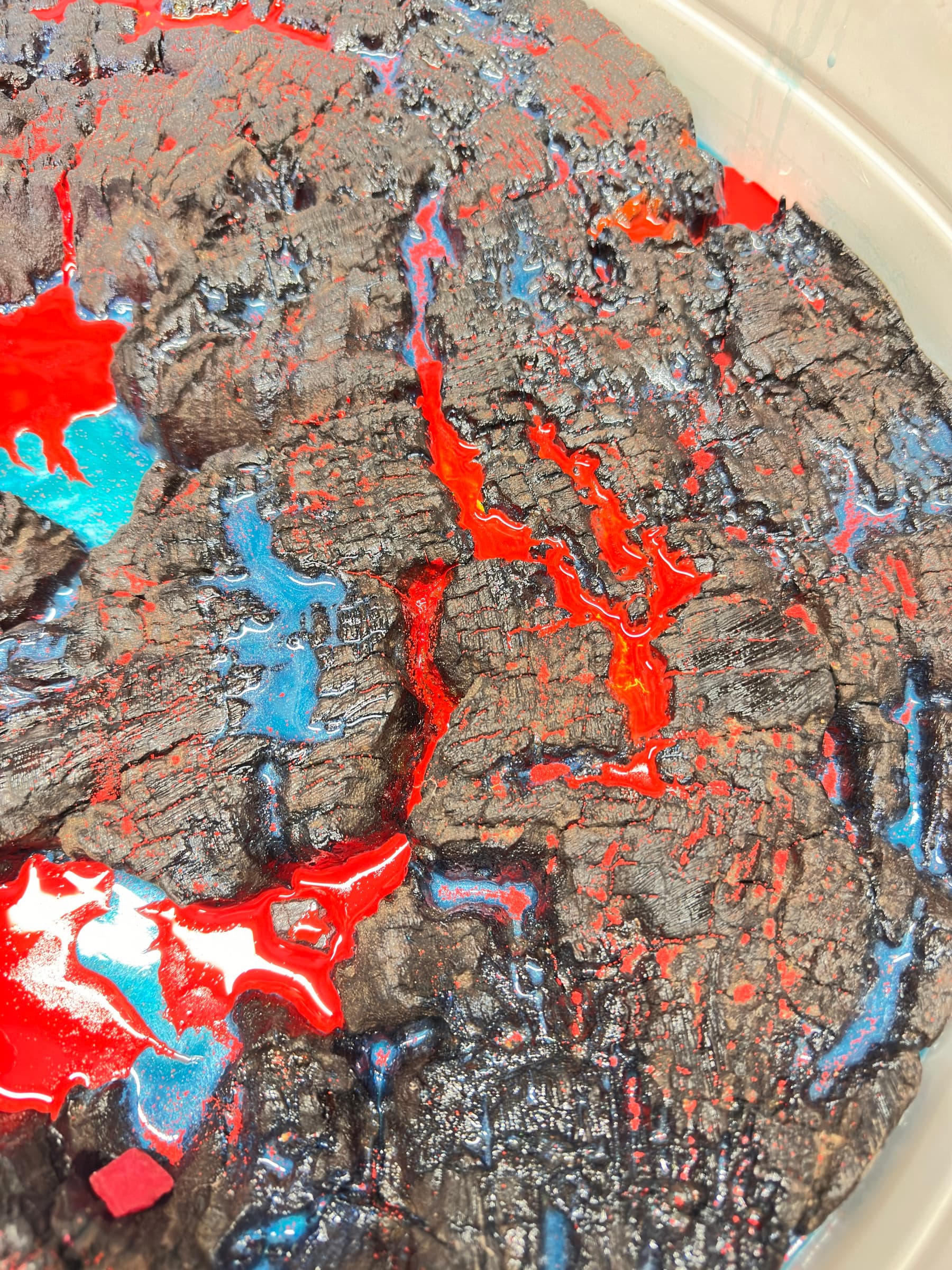 Macro detail of the lava-resin fill in the charred wood