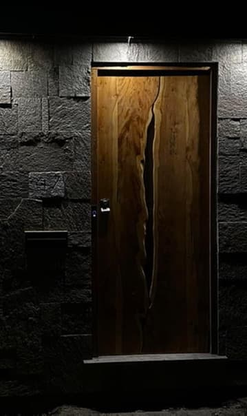 Tight night crop of the door showing the full natural fissure through the grain