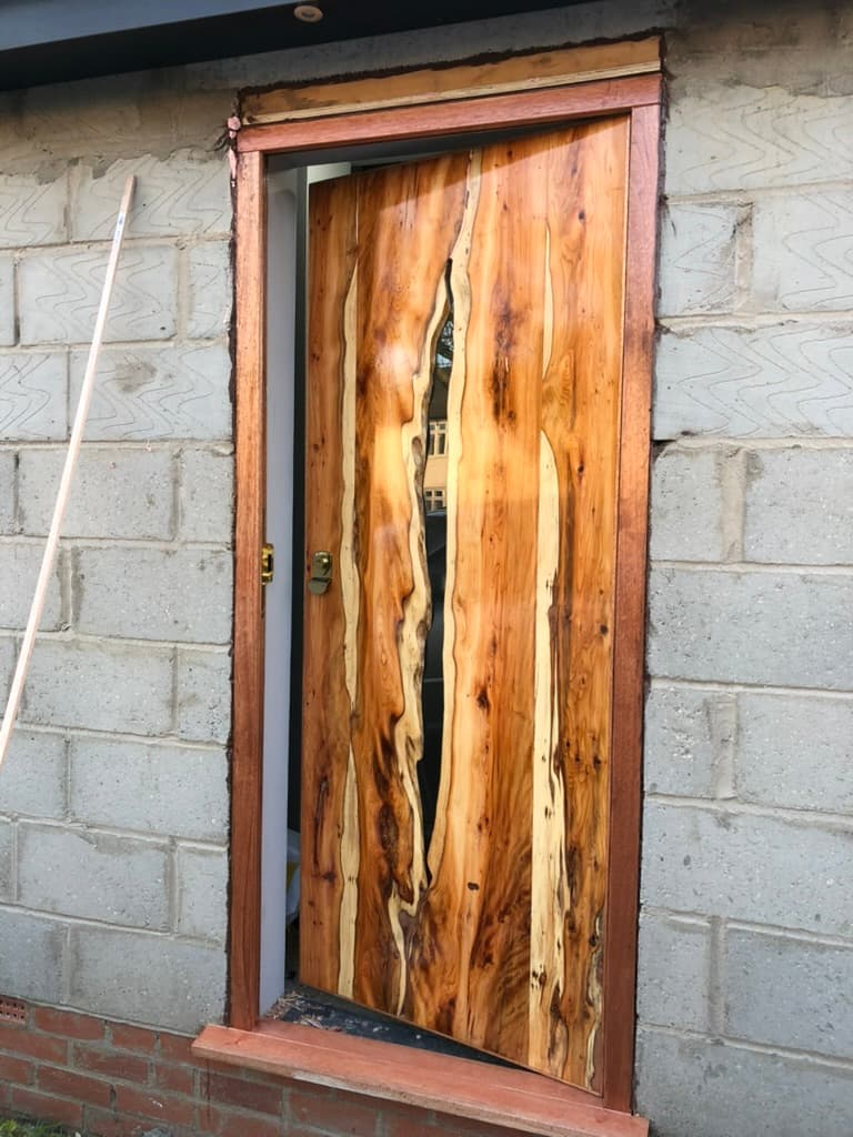 The door mid-installation, bare breeze-block opening, before the stone cladding was applied