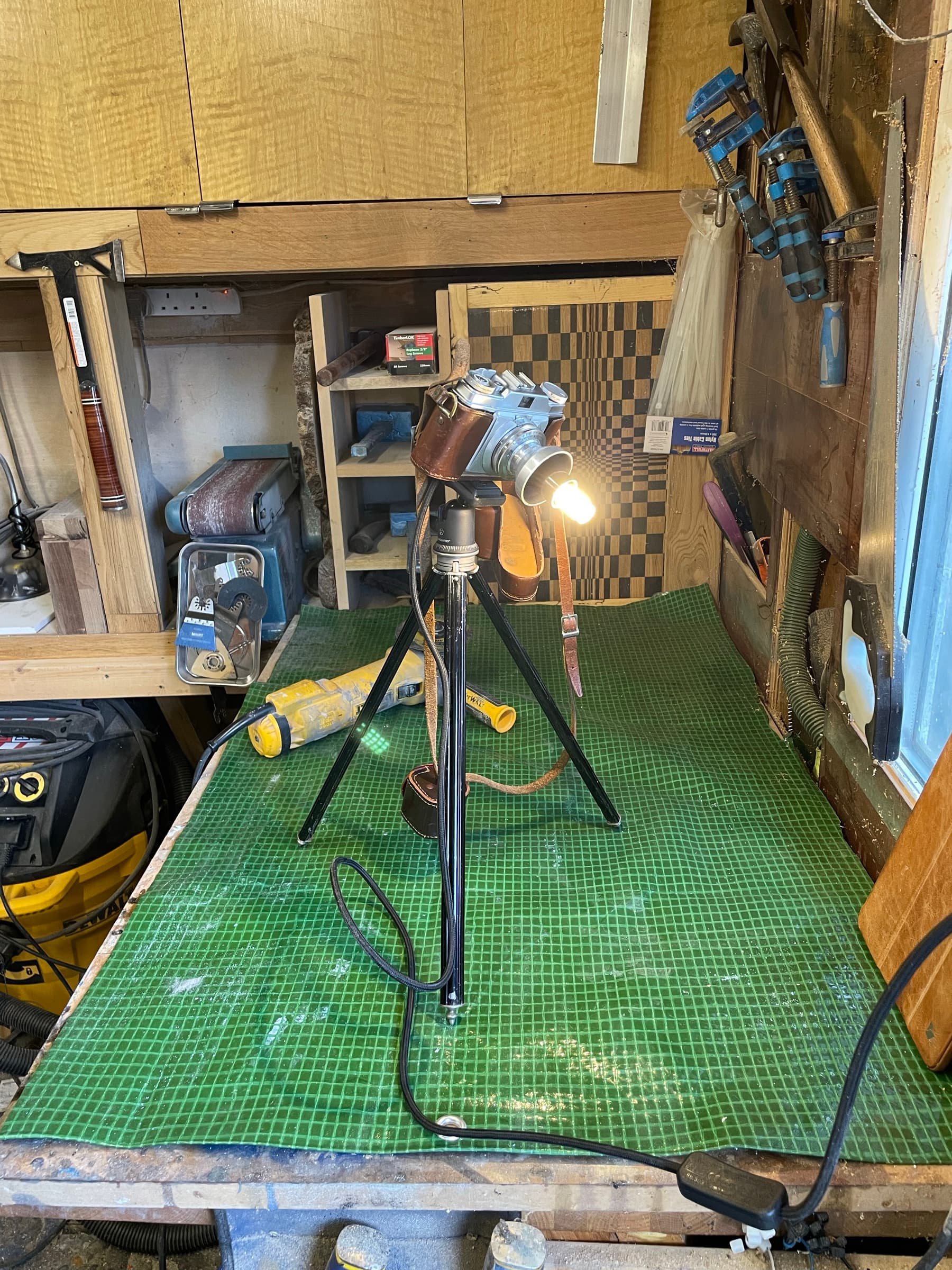 The camera lamp on a cutting mat in the workshop, tools around it