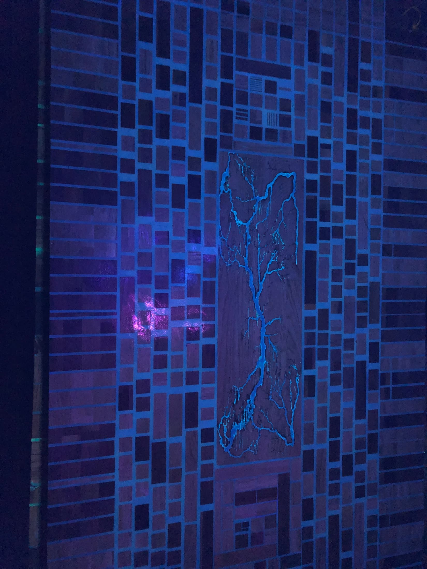 Close detail of the blacklight-reactive resin glowing blue