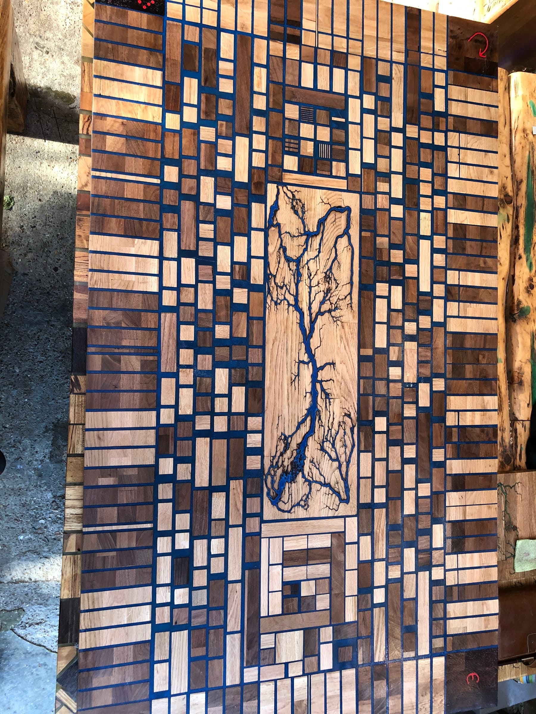 End-grain parquetry tabletop with a central Lichtenberg burn inlay, shown in true daylight colour
