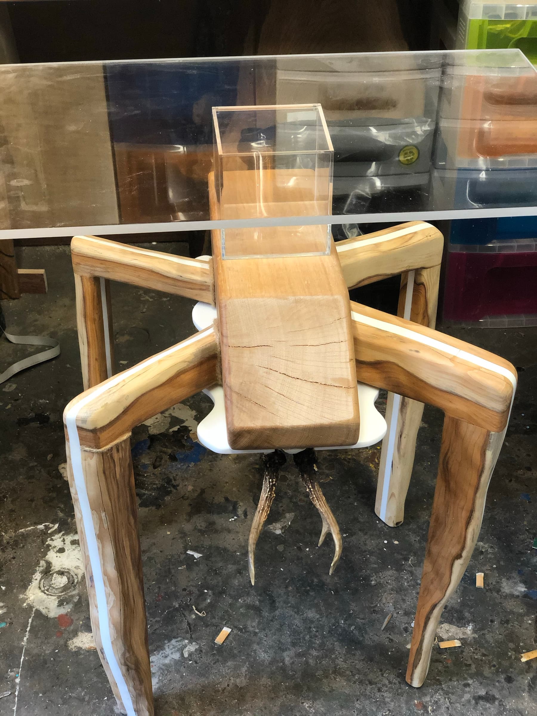 The finished eight-legged table with glass top and empty acrylic display case, workshop