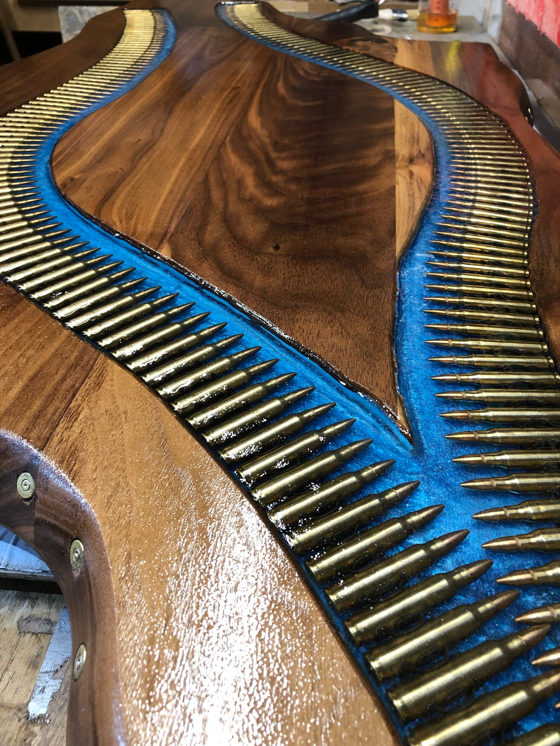 Close detail of brass cartridge casings set nose-to-tail in blue resin