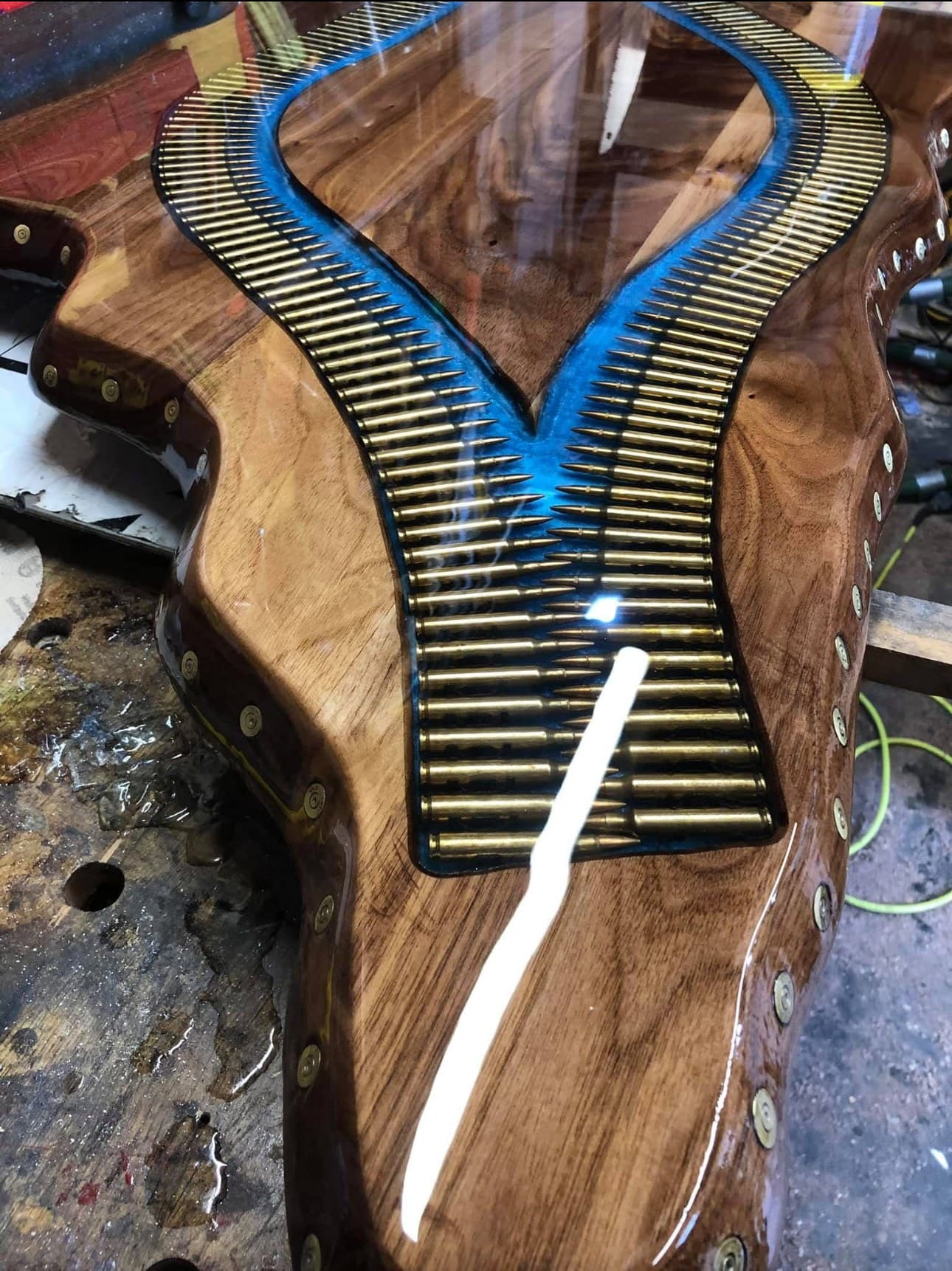 Close detail of the brass cartridge casing river narrowing to a point, blue resin