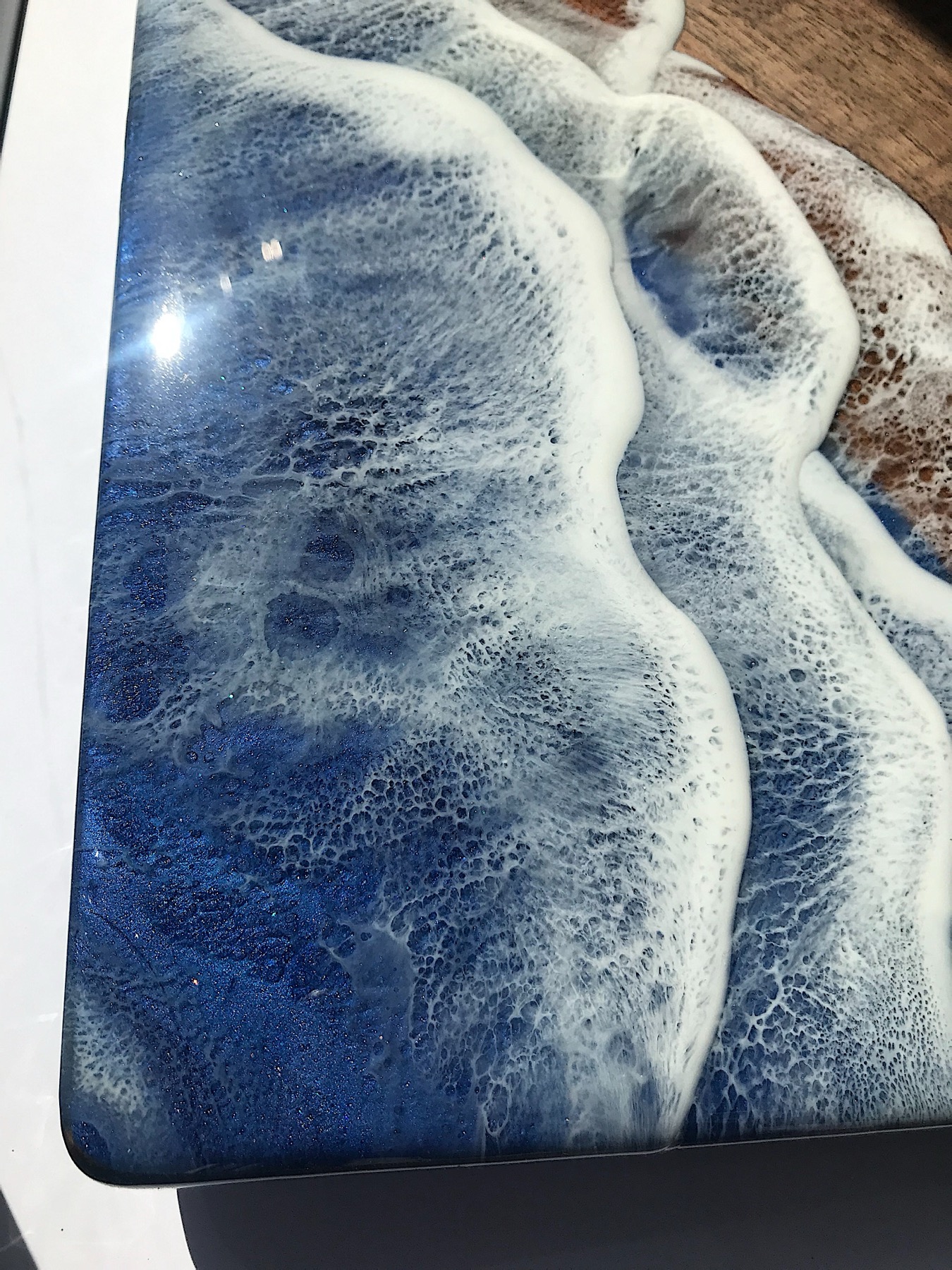 Dramatic macro of a black, white and blue wave-pattern resin board