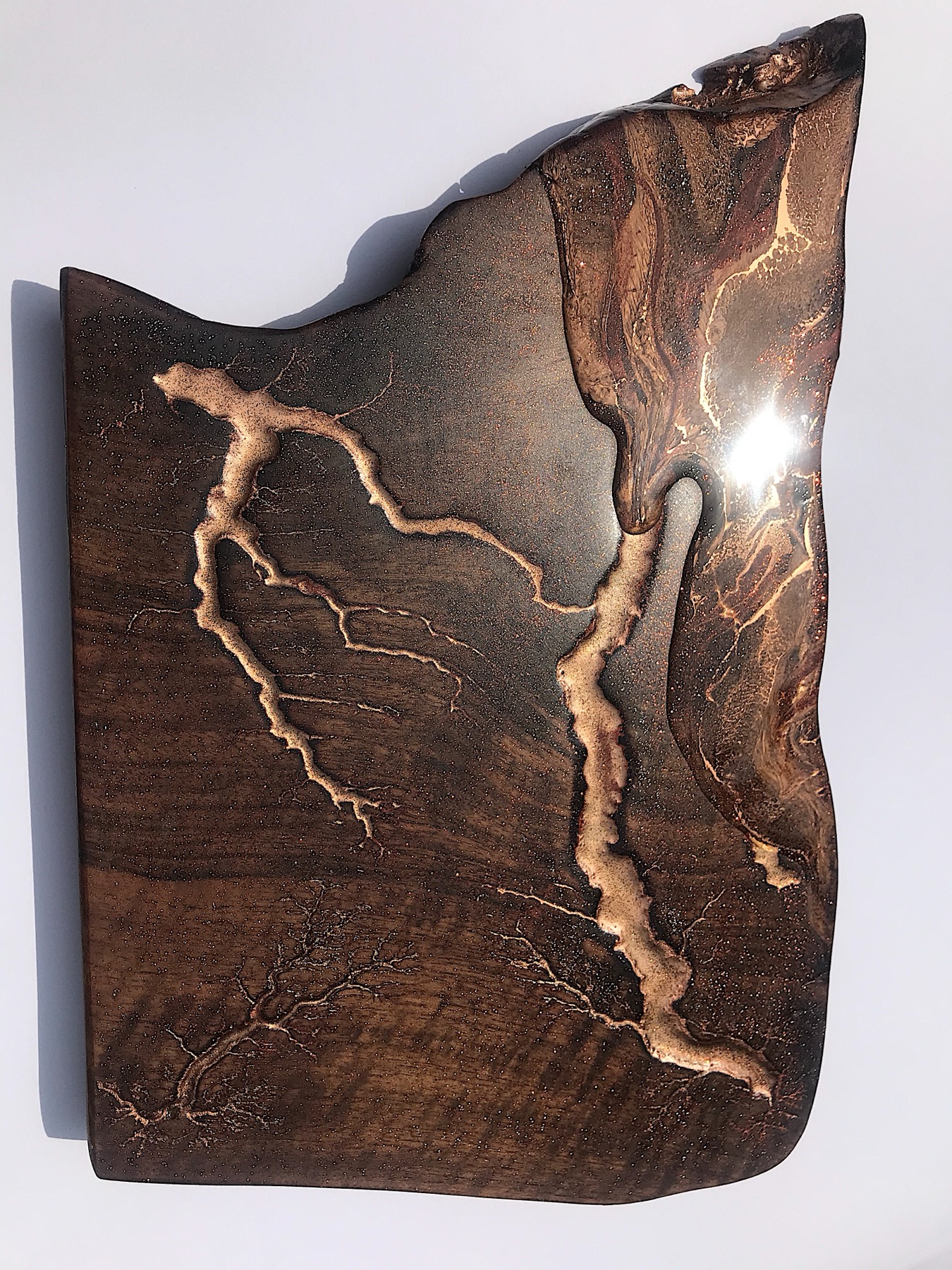 Gold Lichtenberg branching across a dark board, dramatic lighting