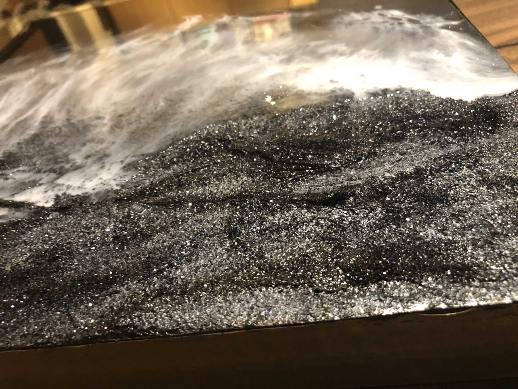 Alternate angle of the black glitter wave-resin board catching the light