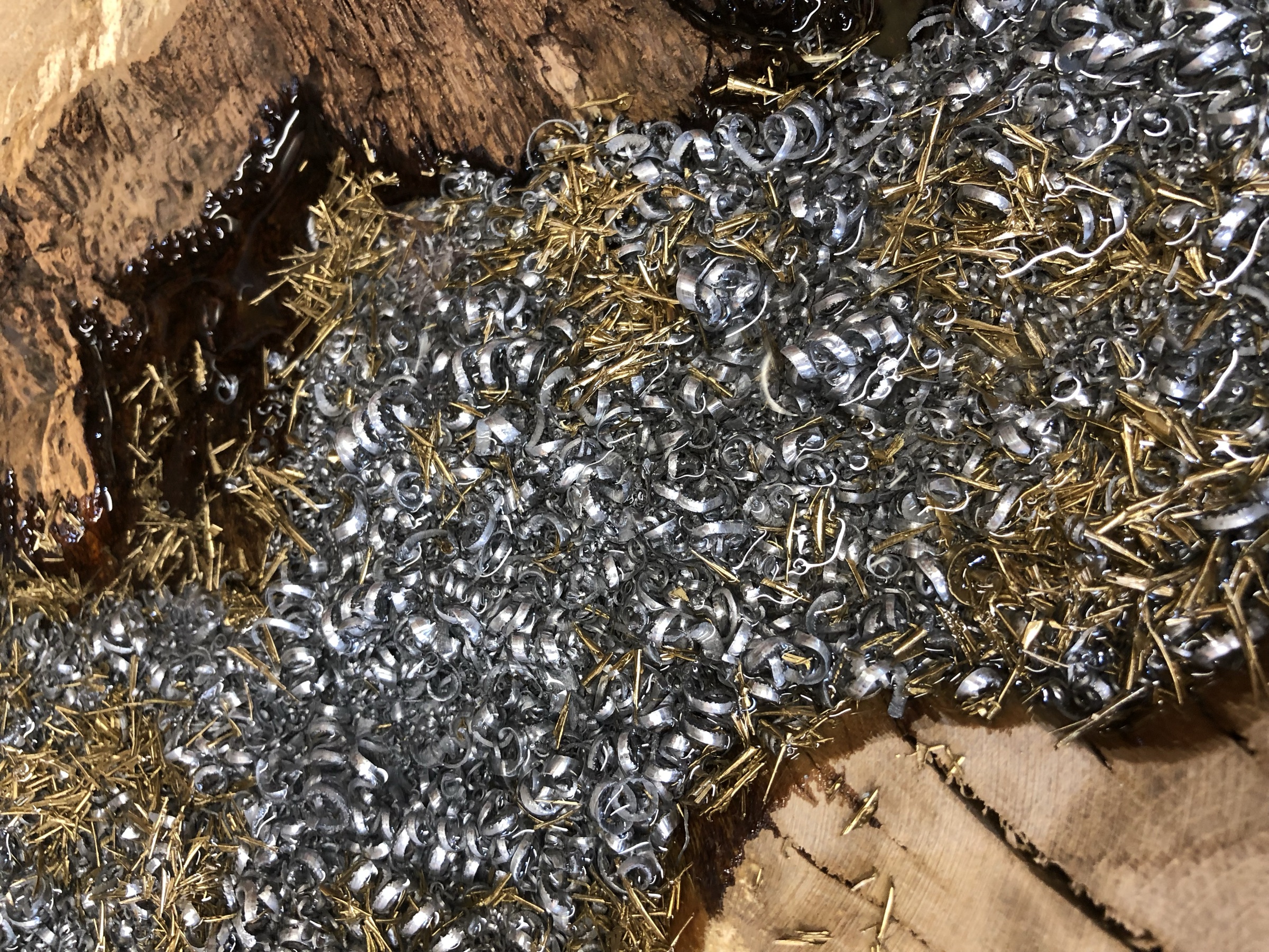 Close view of raw steel shavings and brass pins arranged before casting