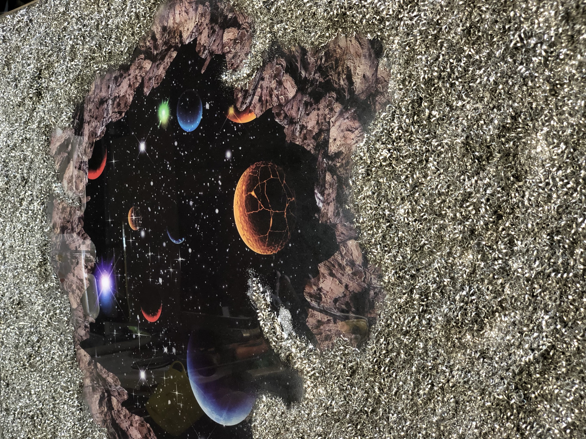 Close view into the painted starfield and planets through the broken opening