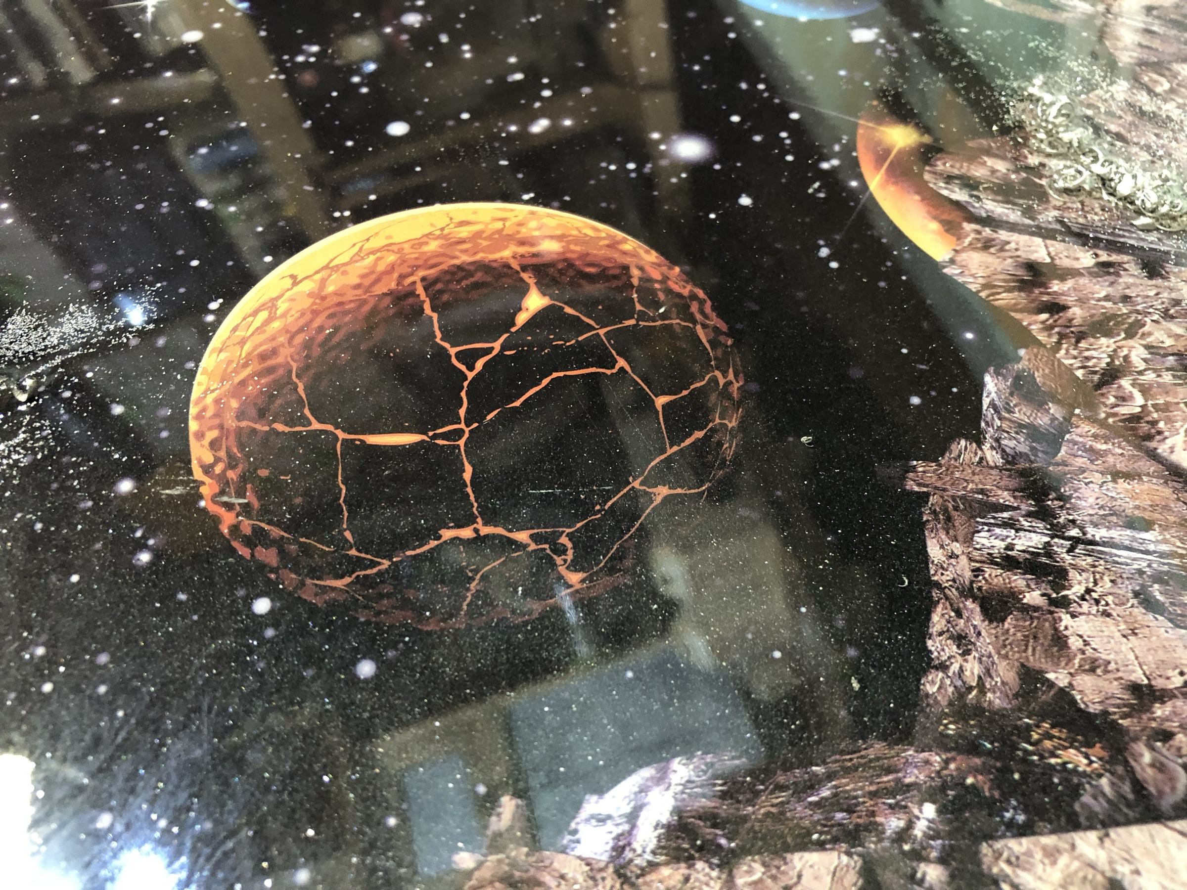 Macro detail of a cracked orange planet within the scene