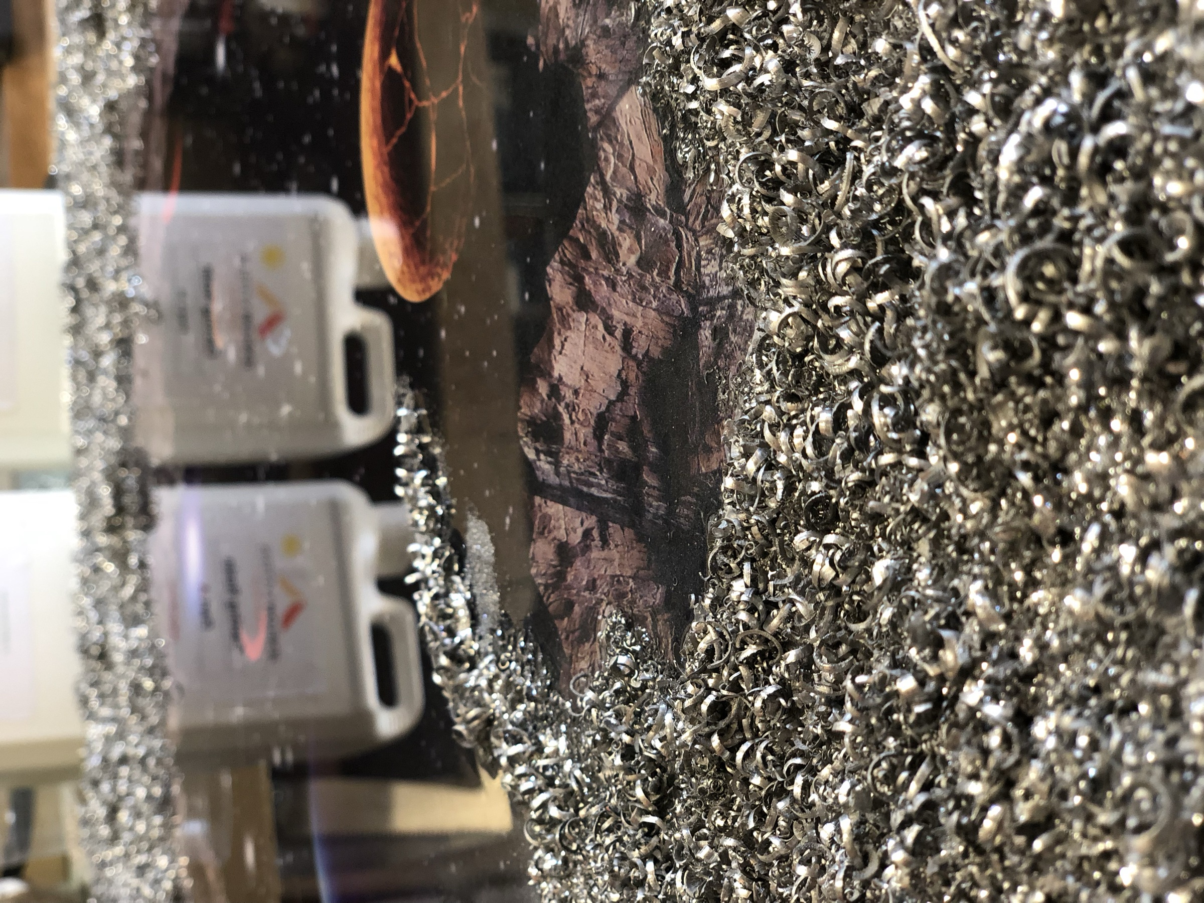 Steel wool shavings and casting resin materials laid out beside the piece, workshop
