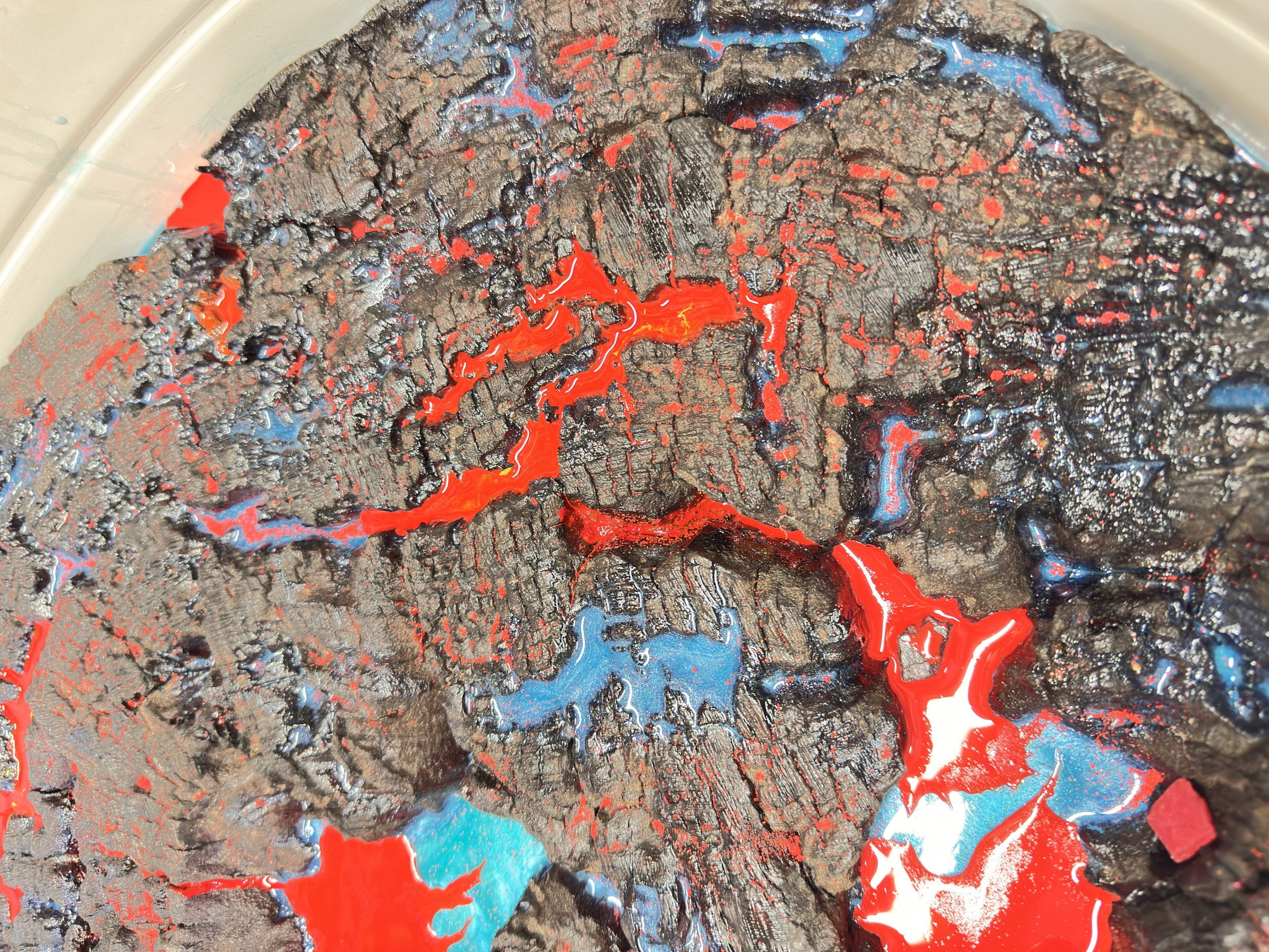 Macro detail of the lava-resin fill in the charred wood