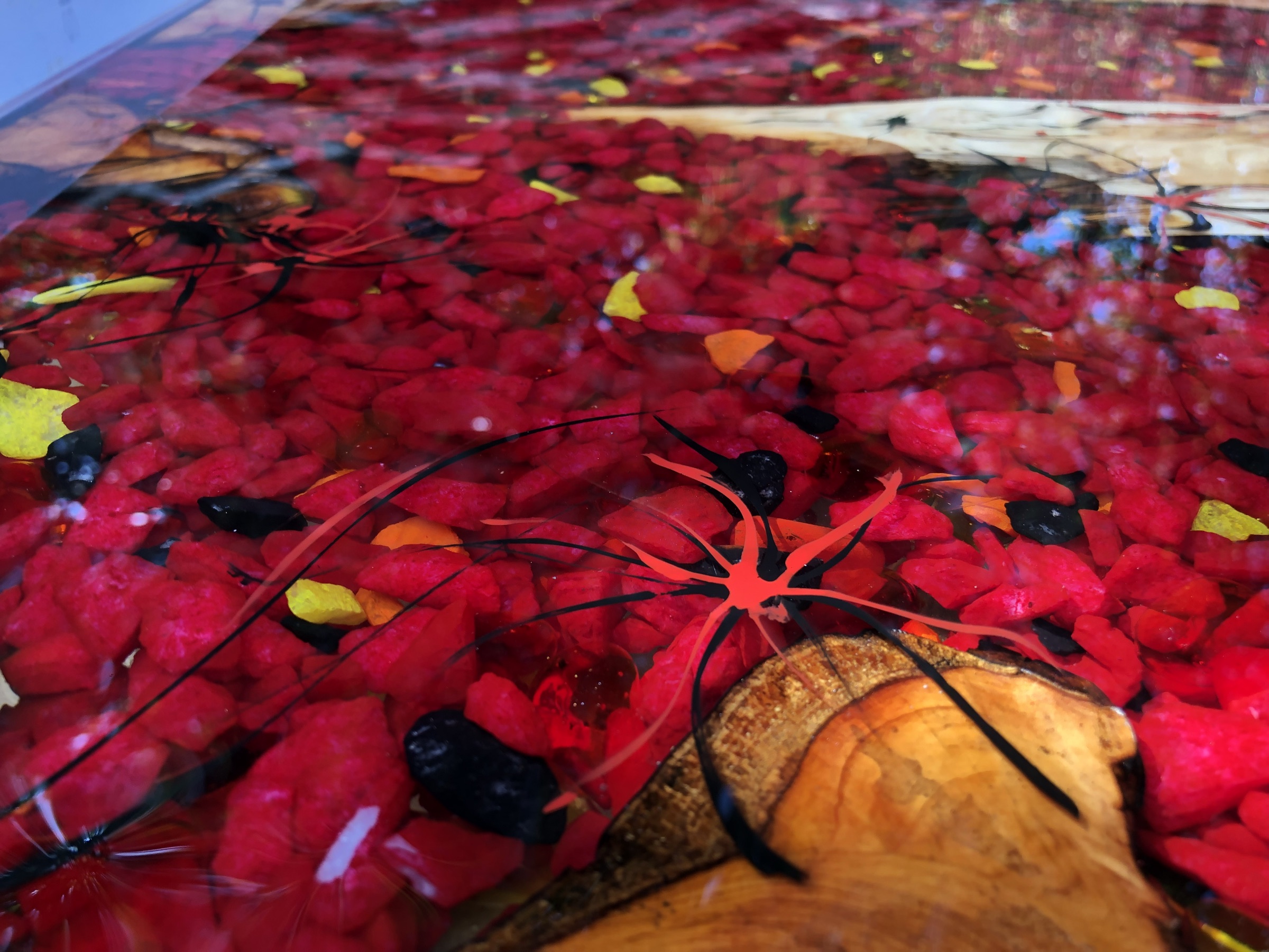 Close detail of red and amber glass chips with a black Lichtenberg-branched resin accent