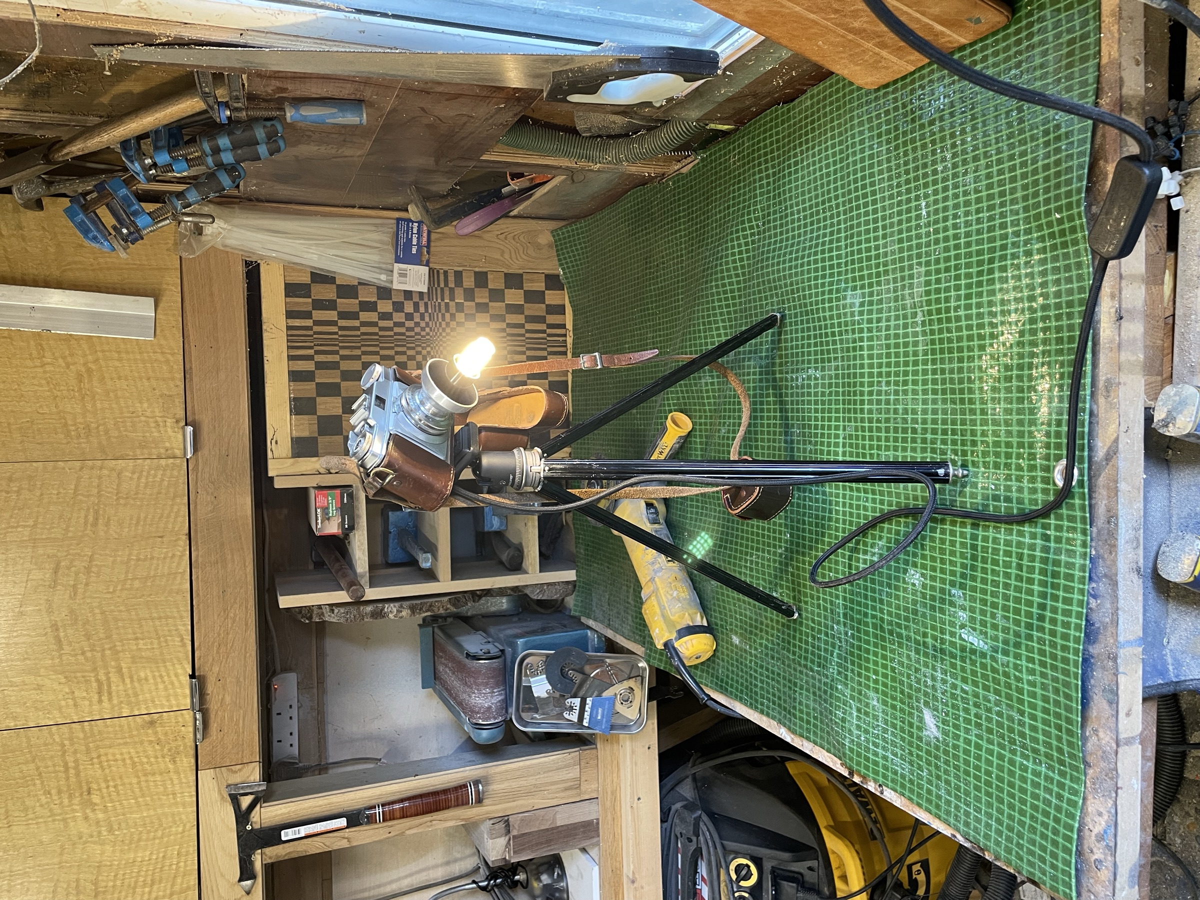 The camera lamp on a cutting mat in the workshop, tools around it