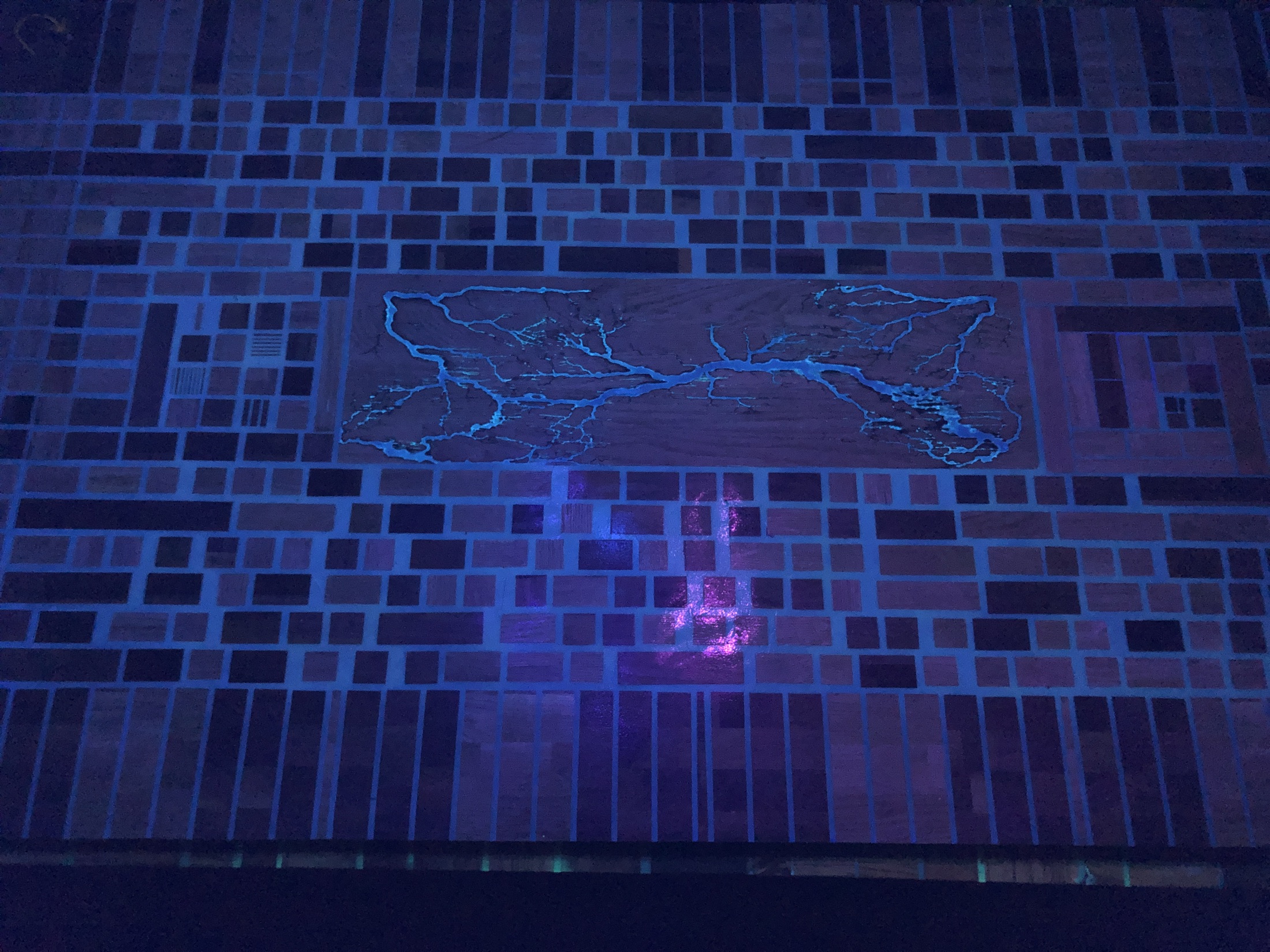 Close detail of the blacklight-reactive resin glowing blue