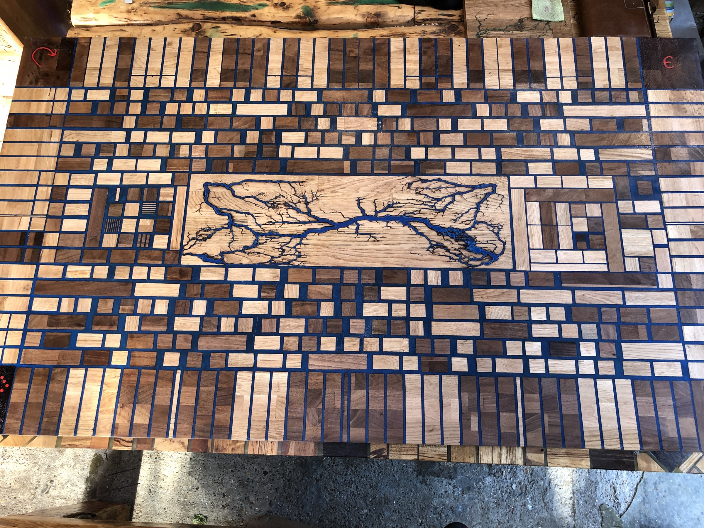 End-grain parquetry tabletop with a central Lichtenberg burn inlay, shown in true daylight colour