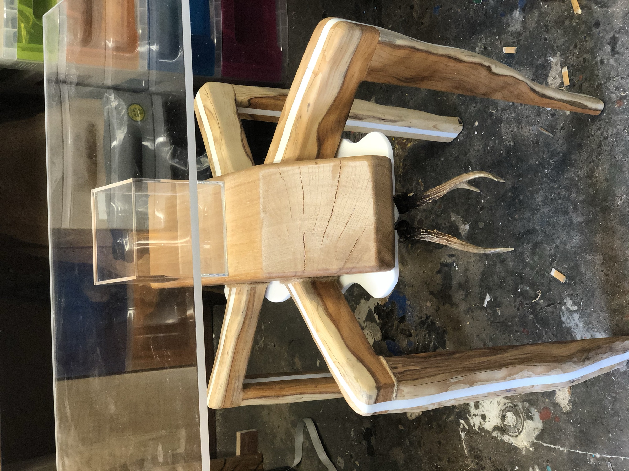 The finished eight-legged table with glass top and empty acrylic display case, workshop